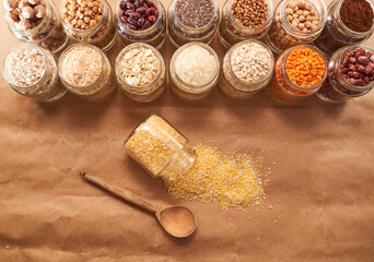 Corn grits scattered on a cherrymeal background with a wooden spoon