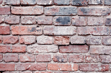 Fragment of an old red brick wall with spots and chips, large brickwork