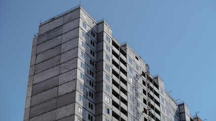 Large construction site on a background of blue sky. Brick, panel apartment building. Industrial theme for design