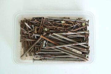 Old nails group in various sizes and types in plastic box.