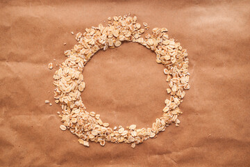 Obraz premium Oat croup in the shape of a circle lies on a brown background