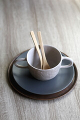 Set of artisan ceramic and cutlery in neutral colors. Selective focus.
