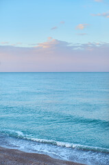 Obraz premium Landscape of the Mediterranean sea without waves at sunset with blue, pink and mauve colors