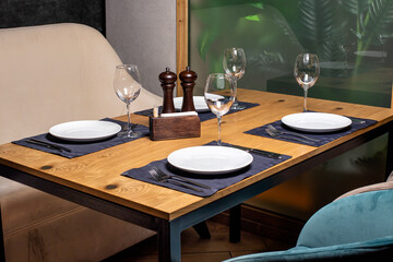 A square wooden table and sofas. A serving table in the restaurant. It's a beautiful serve.