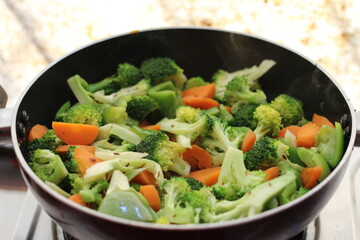 Half cooked vegetables on black fry pan