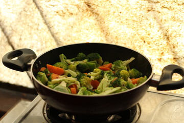 Half cooked vegetables on black fry pan