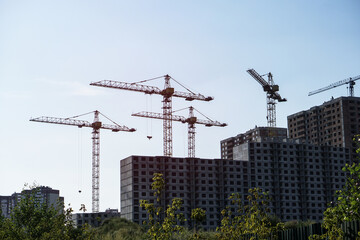 Multi-stage construction during the construction process with a yellow crane. Industrial background for design.