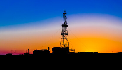 Obraz premium Silhouette of a drilling rig on a sunset background. A golden sunset in the Crimea.