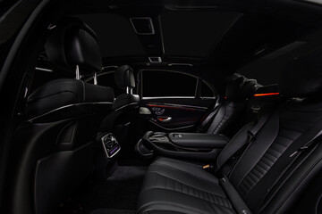 Fototapeta na wymiar Comfortable interior of prestige modern car. Back leather seats with ambient light.