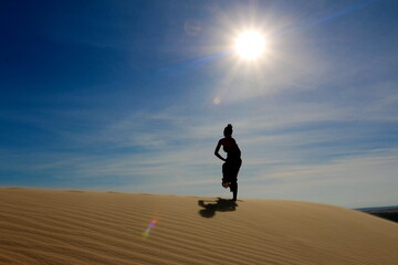 silhouette of a woman walking on the beach