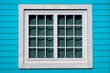 Traditional white wooden window on a blue wall