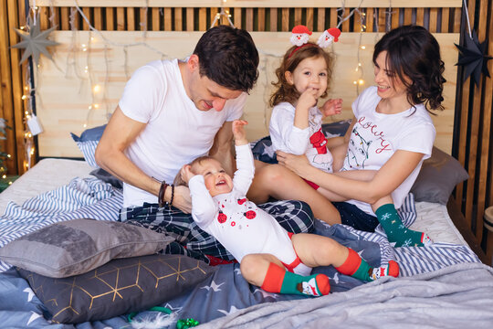 Parents and daughter on the bed in their pajamas have fun. the b