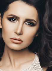 Obraz premium Woman wearing in shine dress with long hair, perfect skin after beauty salon. Professionally haircut, long eyelashes and evening make up. Beautiful brunette girl posing at camera. Gray background.