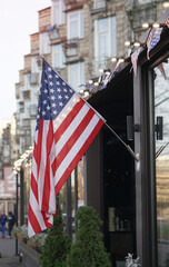 American flag on a building near the road against the background of the city. USA Symbol of power for Independence Day. Urban Temma Nu York. Stock photo