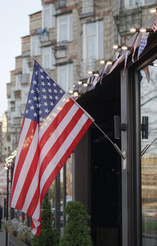 American flag on a building near the road against the background of the city. USA Symbol of power for Independence Day. Urban Temma Nu York. Stock photo