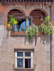 Rome Italy, front of a house and double arch small terrace with  flowers and plants, Trastevere picturesque district