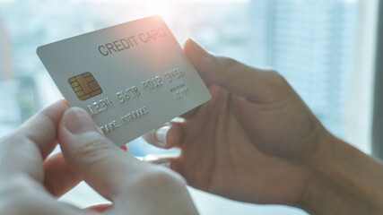 Woman hands holding a white credit card for shopping online or internet banking. Online shopping concept.