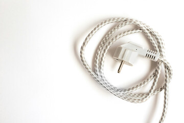 The electric plug is white. Braided cord rolled in a circle.Electric current.