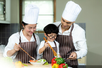 Cooking Family. Chef parent and kid boy make fresh vegetables salad for healthy eat. 