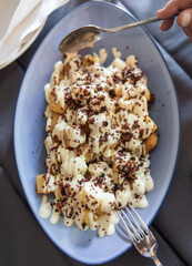 portion of fried potatoes with white sauce and bacon
