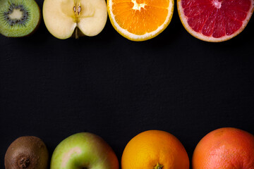 Fresh fruit, orange, apple, kiwi, grapefruit on black