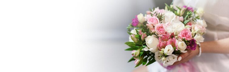 Wedding bouquet in hands of elegant bride. Copyspace with white space for text. Wedding accessories and backgrounds