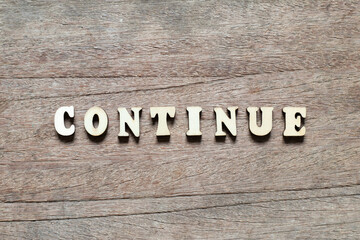 Alphabet letter block in word continue on wood background