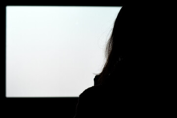 silhouette of a woman watching tv
