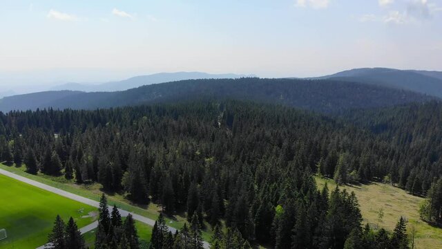 Rogla Slovenia sports resort forest grounds give way to soccer field during the spring season, Aerial flyover shot