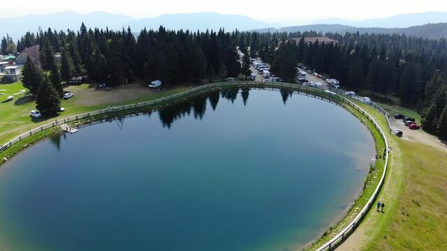 Lake in Rogla mountain sport resort in Slovenia during springtime, Aerial flyover shot