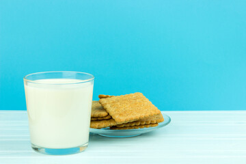 Fototapeta na wymiar glass of milk and a plate of cookies on a blue background, copy spaсe
