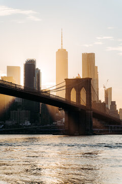 Manhattan and Brooklyn bridge skyline view with sunset and sun flare. World Trade center on background. Vertical image