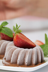 Chocolate fudge garnished with half a strawberry with petals. Garnished with sprigs of mint and...