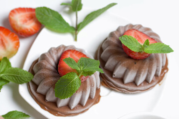 Chocolate fudge garnished with half a strawberry with petals. Garnished with sprigs of mint and...