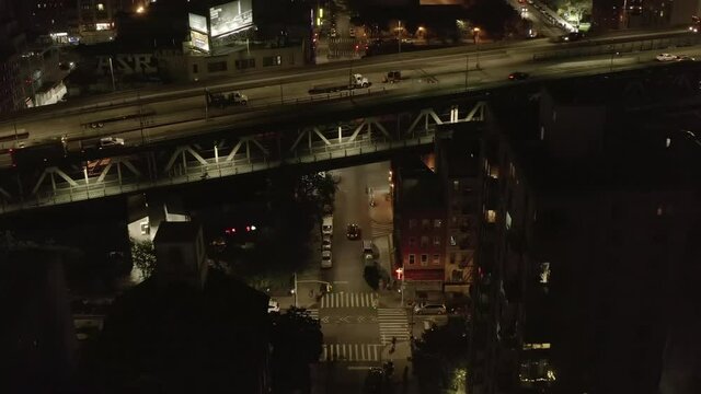 AERIAL: Crane Up lifting View over Williamsburg Bridge Road at Night in Chinatown, Manhattan, New York City