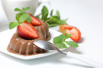Chocolate fudge garnished with half a strawberry with petals. Garnished with sprigs of mint and...