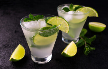 Two cold mojito cocktail on a black background background.