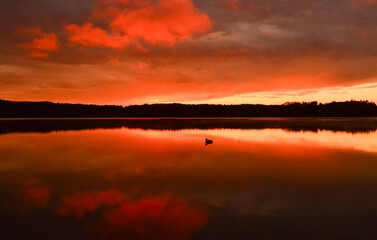 Reflection of orange sunset clouds on lake