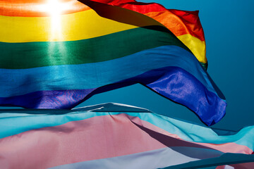 gay and transgender pride flags waving on the sky - obrazy, fototapety, plakaty