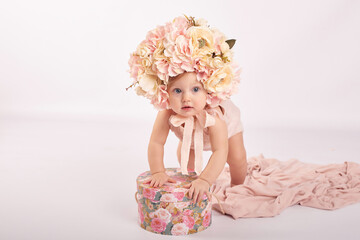 Sweet funny baby in hat with flowers. Easter greeting card, copyspace for your text. Poster for...