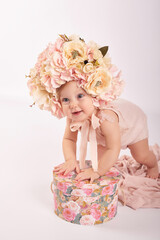 Sweet funny baby in hat with flowers. Easter greeting card, copyspace for your text. Poster for Easter holiday. Congratulations on Mother's Day. Cute baby girl. Children Protection Day