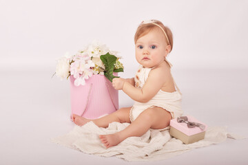 Sweet funny baby in hat with flowers. Easter greeting card, copyspace for your text. Poster for Easter holiday. Congratulations on Mother's Day. Cute baby girl. Children Protection Day.