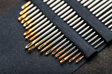 A set of sewing needles on a black background.