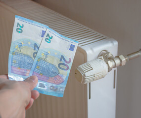 Energy efficiency concept with radiator and euro currency – the cost of thermal energy is more expensive. Selective focus.