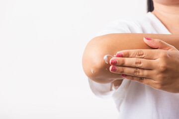 Closeup young Asian woman applies lotion cream on her elbow, studio shot isolated on white background, Healthcare medical and hygiene skin body care concept