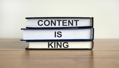 Books with text 'content is king' on beautiful wooden table. White background. Business concept.