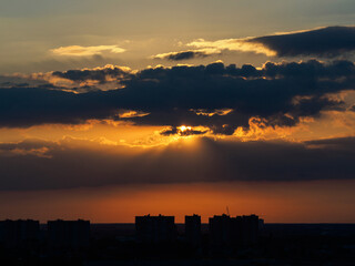 Dark sky with clouds. Sunset over the houses.