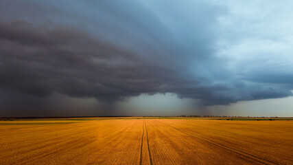 Storm and rainbow in the agricultural plain in summer time aerial photo