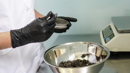 Fototapeta na wymiar Quality black caviar with sturgeon. Workshop for the production of a quality product. Beluga and trout in the food industry. Stock photo