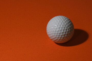 a Golf ball on an orange background